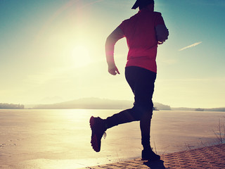 Single man running workout, excercise for run near frozen lake