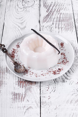 White vanilla milk jelly on ceramic plate on white wooden table