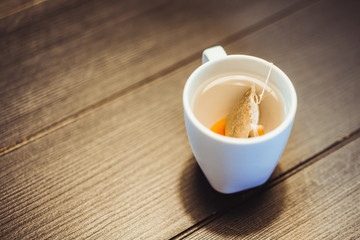 Cup of tea with tea bag on wooden table