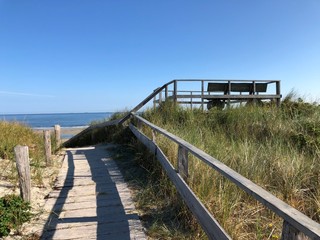 Fototapeta premium Romantischer Blick auf Holzbank vor der Nordsee