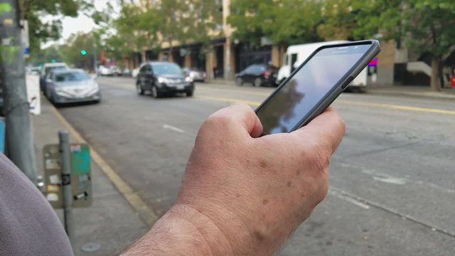 Man summons a ride share vehicle with his smartphone