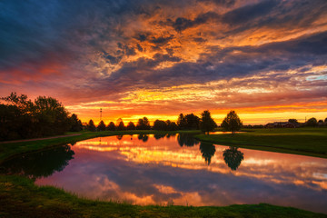 Beautiful sunrise clouds over golf course and lake - 292565179
