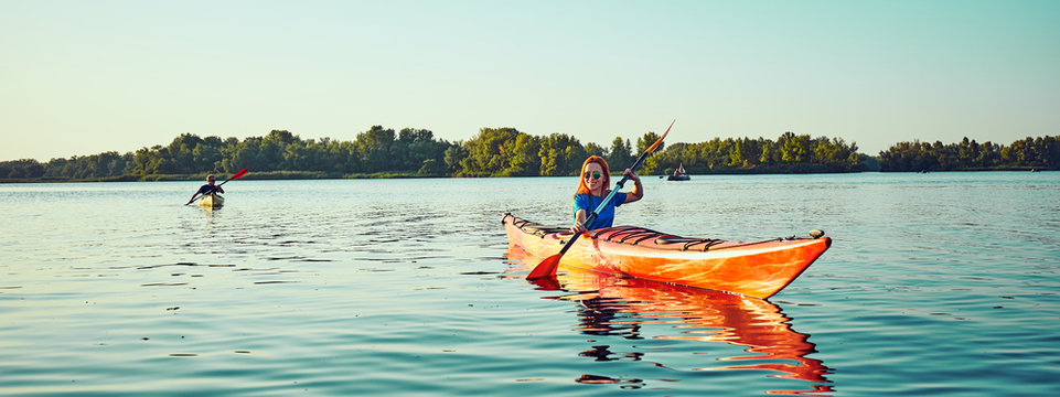 People kayak during sunset in the background. Have fun in your free time.
