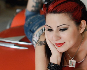 young woman on top of classic red car