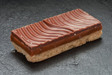 piece of chocolate cake on a plate isolated on black