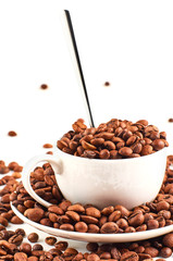 Background of coffee beans and coffee Cup with saucer isolated on white background.