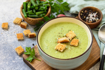 Vegetarian dish. Dietary delicious cream soup of green beans on a light background.