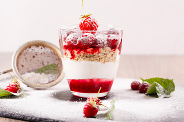 delicious dessert of fresh raspberries and strawberries with oatmeal in a glass glass. Verin.