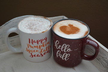 Hot seasonal beverages in mugs on a wooden tray