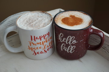 Hot seasonal beverages in mugs on a wooden tray