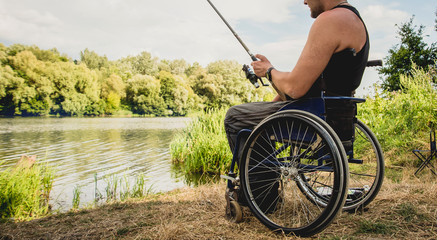 Handicapped man fishing at a lake. Wheelchair. Camping.