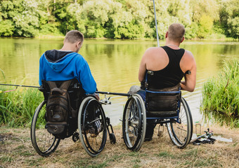 Handicapped men fishing at a lake. Wheelchair. Camping.