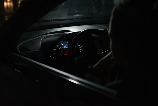 Man Driver In Suit Sitting Behind The Wheel Of A Car View From Inside