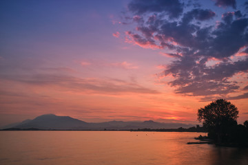 Obraz premium Sunrise over the lake. Reflection of the sun in the water.