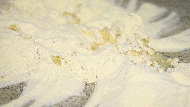 A man prepares to knead the dough for panzerotti or pies: pours water into flour and olive oil. Durum wheat flour, Senatore Cappelli