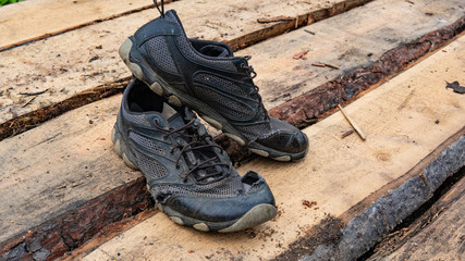  torn old shoes on the background of boards