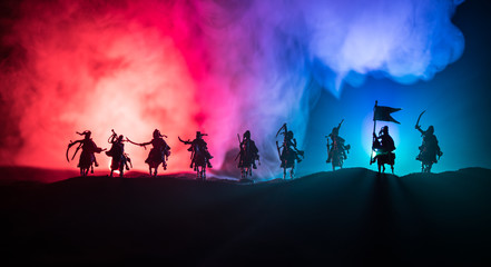 Medieval battle scene with cavalry and infantry. Silhouettes of figures as separate objects, fight between warriors on dark toned foggy background. Night scene. - obrazy, fototapety, plakaty