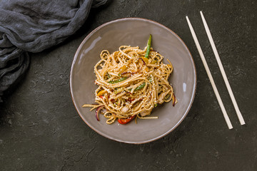 chicken wok noodles on dark stone table