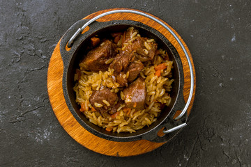 pilaf with beef on black concrete table