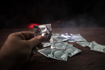 Close up of a young beautiful girl holding an open female condom, safe sex concept. Protection against AIDS and birth control