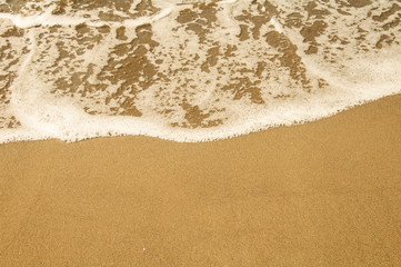 Fototapeta na wymiar sea foam and yellow sand background