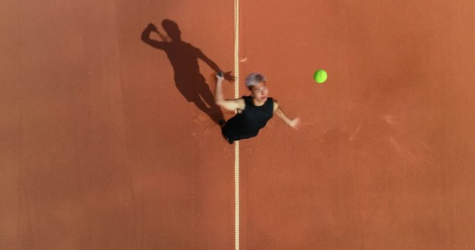 A mixed race platinum haired tennis player serves an 'Ace' and celebrates.