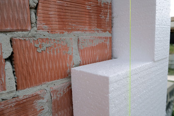 Close-up detail of brick house wall with rigid styrofoam insulation sheet. Modern technology of...
