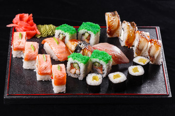 Japanese food, tasty of meal for lunch. Seafood. Sushi with eel, salmon, trout, tuna black background.