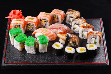 Japanese food, tasty of meal for lunch. Seafood. Sushi with eel, salmon, trout, tuna black background.