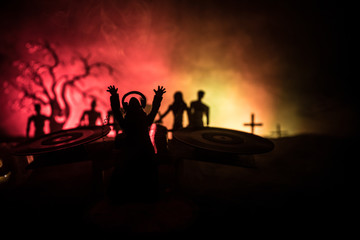 Fototapeta premium Scary view of zombies at cemetery dead tree, moon, church and spooky cloudy sky with fog, Horror Halloween concept. Toned