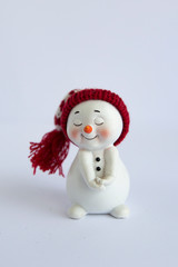 cheerful snowman in a fur hat and scarf, in a jacket on a white background. Concept of winter, christmas and new year. Isolated christmas symbol.