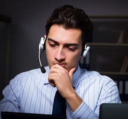 Call center operator talking to customer during night shift