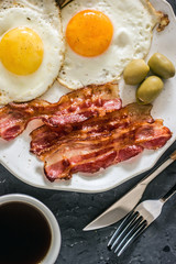 Fried eggs with bacon in a pan. Classic bacon and eggs. Keto Diet LCHF Keto breakfast. Low carb diet concept. high fat diet.  Fried eggs and crispy bacon closeup