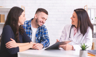 Cheerful doctor showing good analysis results to happy man