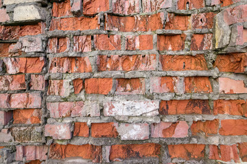 Wall of red broken bricks, background and texture