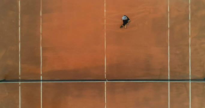 A mixed race platinum haired male tennis player sprints across court, volleys the ball across the net and celebrates.