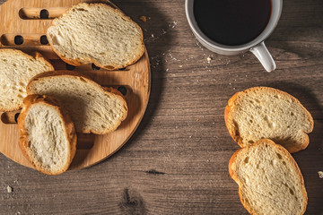 bread for breakfast, with cup of coffee over rustic wooden background with copy space. Morning breakfast with coffee and toasts.