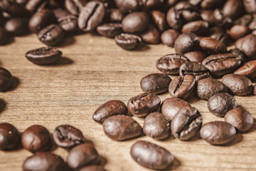 Coffee on wooden background. Brown roasted coffee beans, seed on dark background. Espresso dark, aroma, black caffeine drink. Closeup isolated energy mocha, cappuccino ingredient.