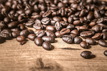 Coffee on wooden background. Brown roasted coffee beans, seed on dark background. Espresso dark, aroma, black caffeine drink. Closeup isolated energy mocha, cappuccino ingredient.
