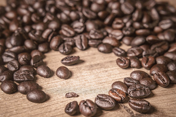 Coffee on wooden background. Brown roasted coffee beans, seed on dark background. Espresso dark, aroma, black caffeine drink. Closeup isolated energy mocha, cappuccino ingredient.