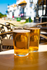 Cold amber color light spanish beer served in glass in outdoor cafe in town on sand, El Rocio in Andalusia, Spain