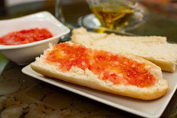 Traditional andalusian breakfast with bread toasts, fresh ground tomatoes and olive oil