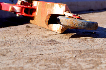 Old red rusty abandoned scooter lying on the concrete floor.