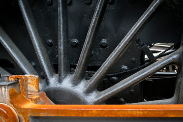 Industrial or transportation or steam punk vintage background with detail of old rusty steam locomotive featuring crank mechanism, frame and  wheels. 