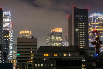 Japanese abstract urban background featuring details of chaotic city buildings and skyline in Tokyo downtown in Ginza district at night time in July.   
