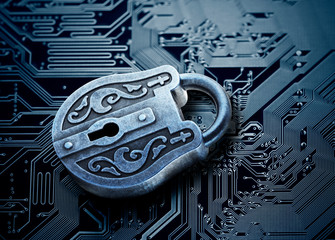 Computer security concept. Old mysterious padlock on computer circuit board 