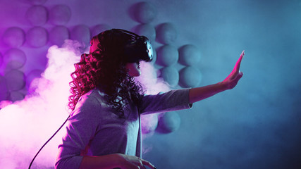 Virtual reality game. A girl in a virtual reality helmet plays a game or explores the environment.