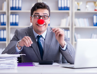 Clown businessman burning paper papers in the office