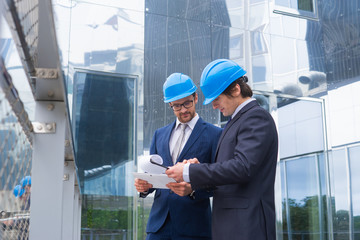 Real estate developers in helmets. New office construction. Confident business men and architect...