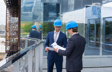 Real estate developers in helmets. New office construction. Confident business men and architect...